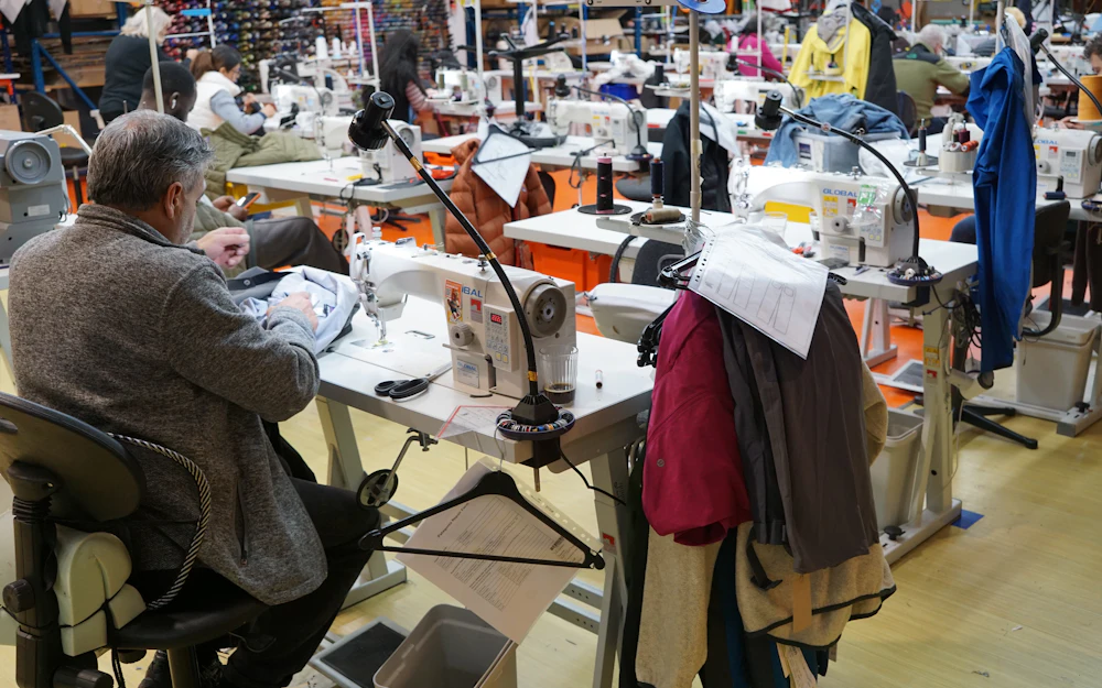 A tailor working at a sewing machine in a workshop