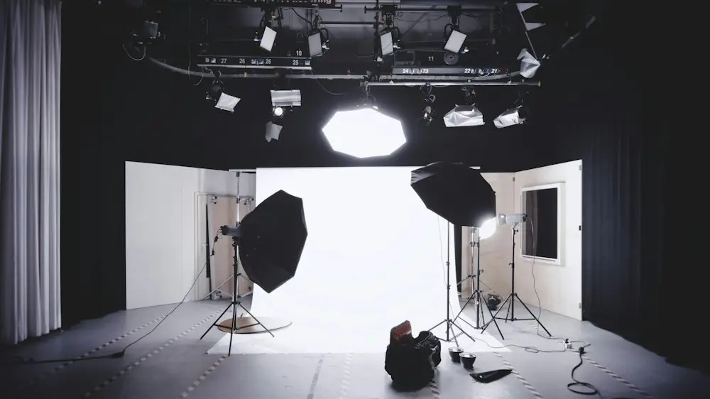 A photo studio with lights and a white backdrop